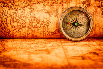 Plakat Vintage compass lies on an ancient world map.