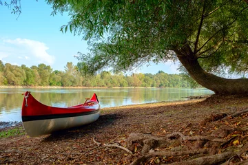 Plexiglas foto achterwand Rode kano op strand bij rivier Donau © Kavita