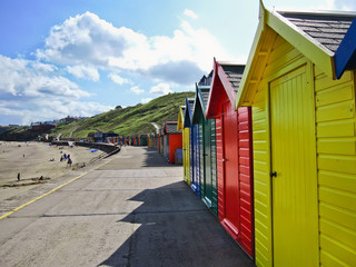 Row of colourful beach huts in Whitby, Yorkshire, England.