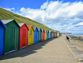 Row of colourful beach huts in Whitby, Yorkshire, England.