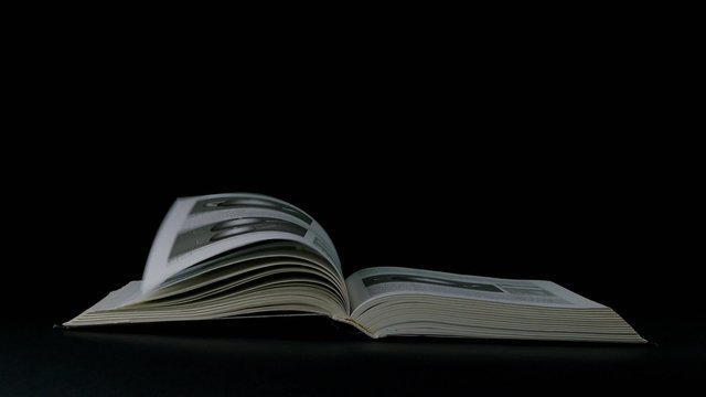 book page turning on black background 4k footage