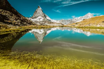 Fotobehang Berg Matterhorn en Riffelsee met gras © ramanauz
