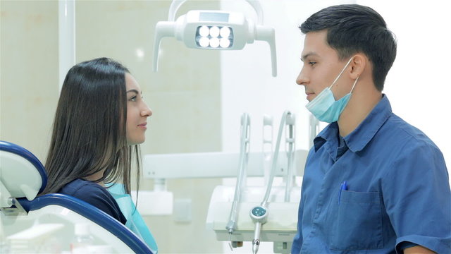 The dentist and young woman patient teeth smile directly into