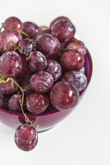 Fresh red grapes in a purple bowl