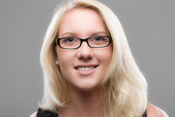 Junge hübsche Frau mit Brille lächelt