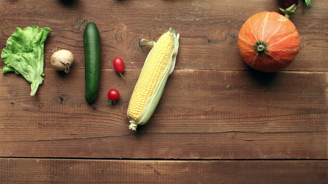 Vegetables filling entire wooden kitchen table - harvest concept - stop motion animation