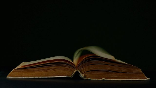 book page turning on black background 4k footage