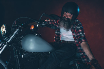 Casual cool long beard man with helmet riding motorcycle at nigh