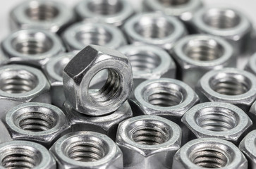 Closeup metal screw (bolt) and nuts on white background.
