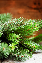 Green fir branches on an old wooden background, selective focus