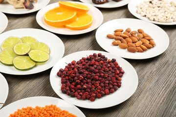 Different products on saucers on wooden table, closeup