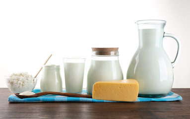 Dairy products on wooden table on white background