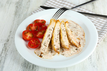 Slices of chicken fillet with spices and cherry tomato on table close up