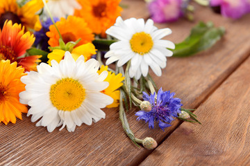 Obraz premium Bright wildflowers on wooden table, closeup