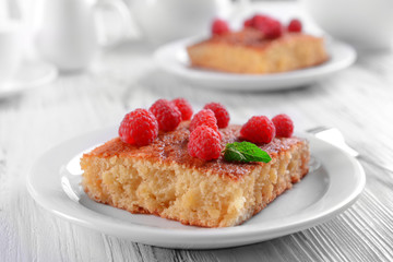 Fresh pie with raspberry in white plate on wooden table, closeup