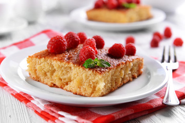 Fresh pie with raspberry in white plate on wooden table, closeup