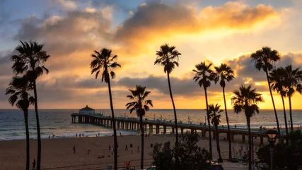 Foto op Plexiglas Los Angeles Palmbomen over het strand en de pier van Manhattan bij zonsondergang in Los Angeles.