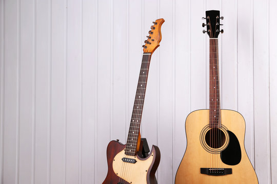 Guitars on white wooden wall background