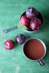 Delicious plum juice with fruits on wooden table close up