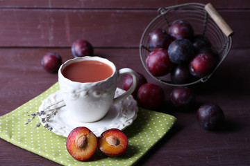 Delicious plum juice with fruits on wooden table close up