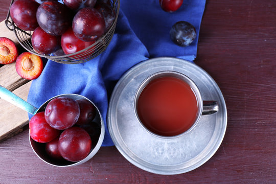 Delicious plum juice with fruits on wooden table close up