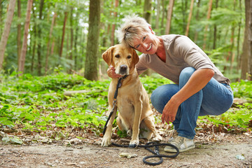 Frau mit Labrador Retriever im Wald