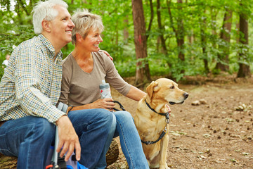 Paar Senioren mit Hund im Wald