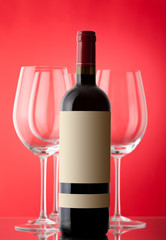 Unopened wine bottle on a red background