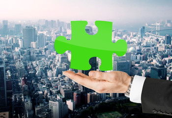close up of man holding green puzzle piece