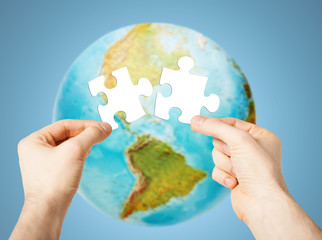 hands with white blank puzzle over earth globe