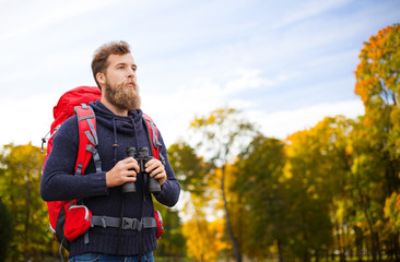 man with backpack and binocular outdoors