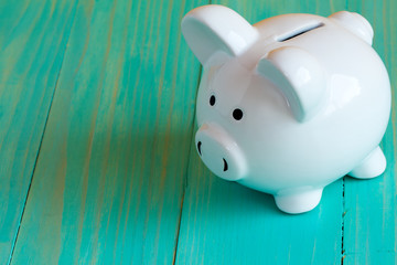 Piggy bank on the blue wooden surface