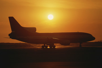 Fototapeta na wymiar Jet airplane on tarmac at sunset