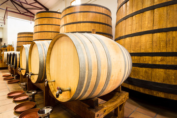 Big and small yellow barrels with iron rims and plastakovy bottles with drinks.