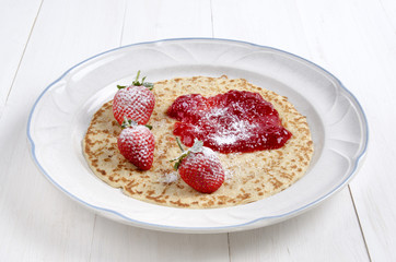 baked pancake with strawberries and jam