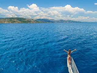 Obraz premium woman standing on rostrum of sailing yacht