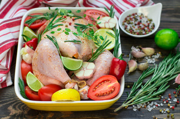 Raw chicken ready for roasting with vegetables - tomatoes, garli