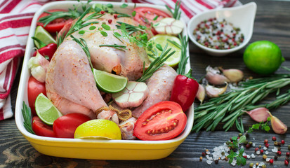 Raw chicken ready for roasting with vegetables - tomatoes, garli