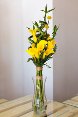 Bunch of yellow callas in the vase on white background