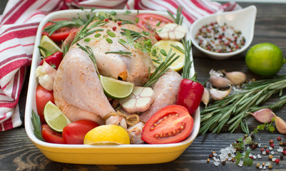 Raw chicken ready for roasting with vegetables - tomatoes, garli