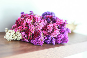 colourful statice flower on wooden floors