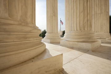 American flag viewed between columns of Supreme Court building