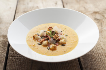 Pumpkin soup on wooden surface