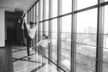 Mother learning daughter to make a high leg strech