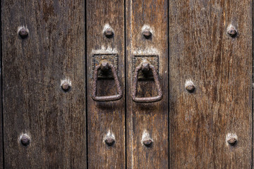 Detail close up of old wooden door with rusty door pulls.  Mediaeval look