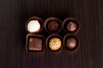 Delicious chocolate candies on wooden background