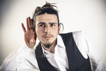 Young man holding a hand to his ear
