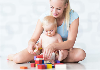 Obraz na płótnie Canvas Mother and baby playing with blocks