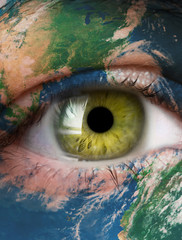 Planet earth and green human eye. Elements of this image furnished by NASA