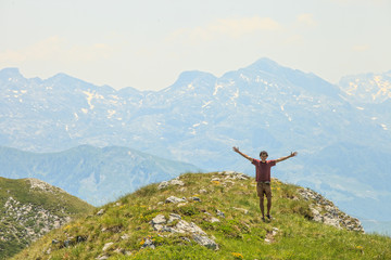 Happy young male traveler enjoying the beautiful view of Visitor mountains in Montenegro
